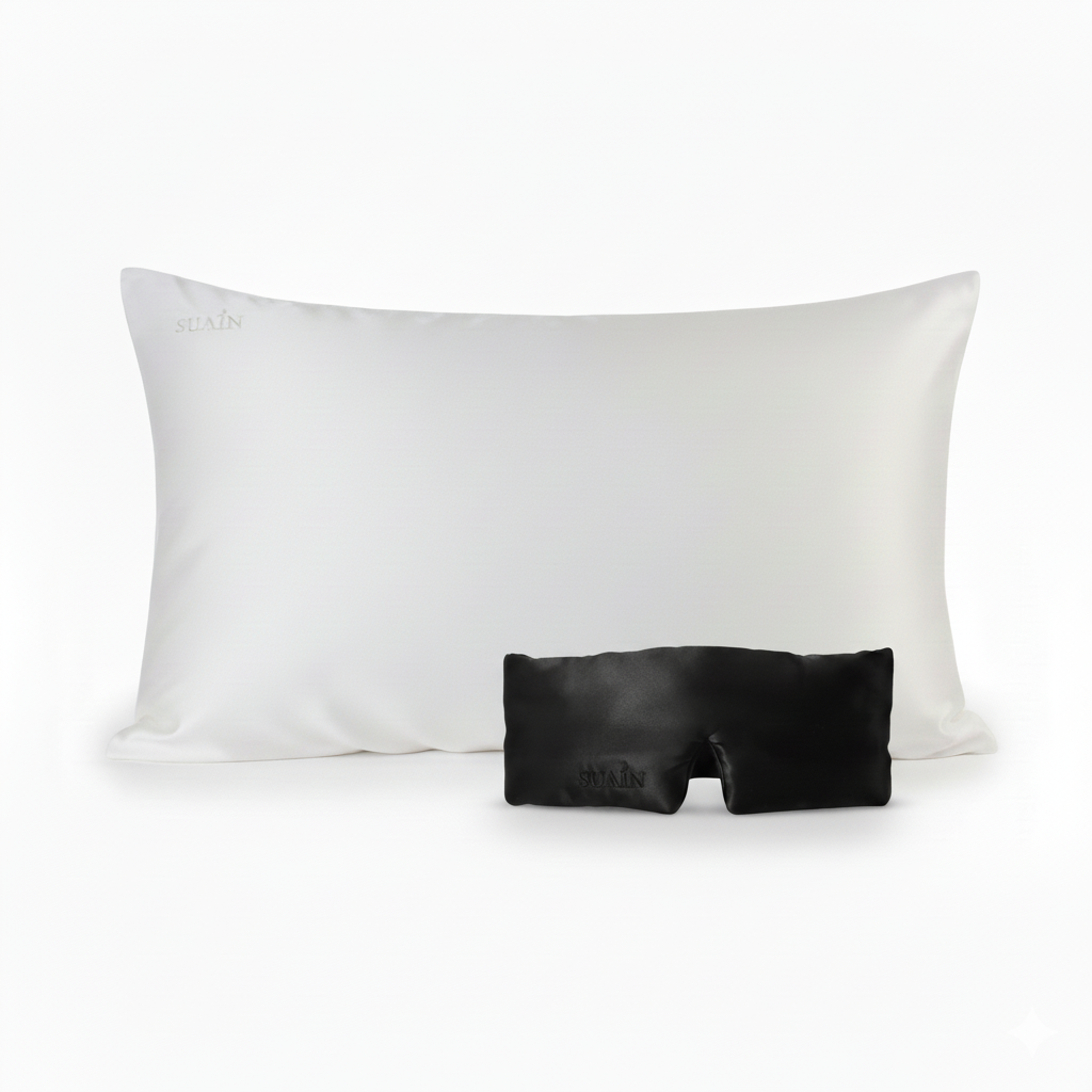 A black mulberry silk sleep mask and white silk pillowcase.