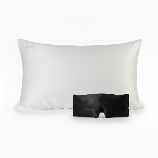 A black mulberry silk sleep mask and white silk pillowcase.